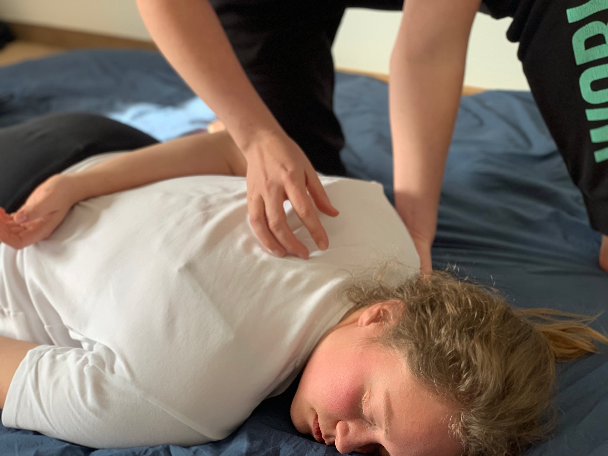 Evy geeft een rustgevende shiatsu-basisbehandeling tijdens de cursus voor mensen